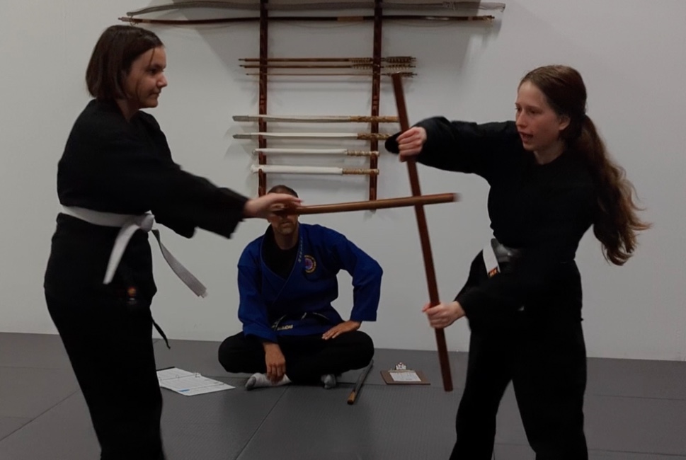 2 young women practicing bojutsu Japanese stick art