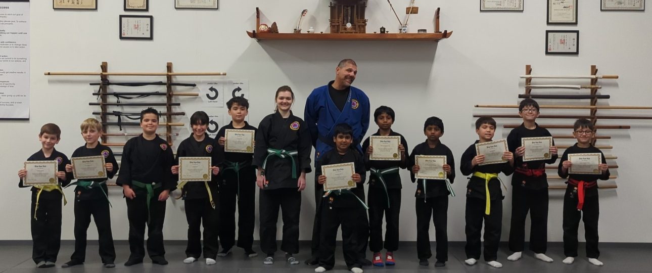 Kids displaying certificates from passing their belt rank promotion exams at Shin Gan Dojo in Liberty Hill Texas